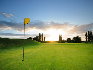 golf flag on the green against the sunrise